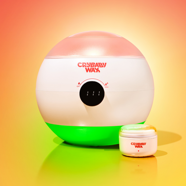 The Meltdown Machine wax warmer with digital display beside a jar of Crybaby Wax hard wax