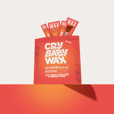 Stiff Upper Rip wax pull tabs and Crybaby Wax bag on a gradient background, patented biodegradable handle tabs for cleaner hard wax removal